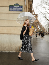 a lady wears a black and white floral printed skirt with a black top